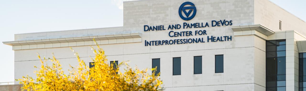 Daniel and Pamela DeVos Center for Interdisciplinary Health in the Fall with yellow tree in the foreground